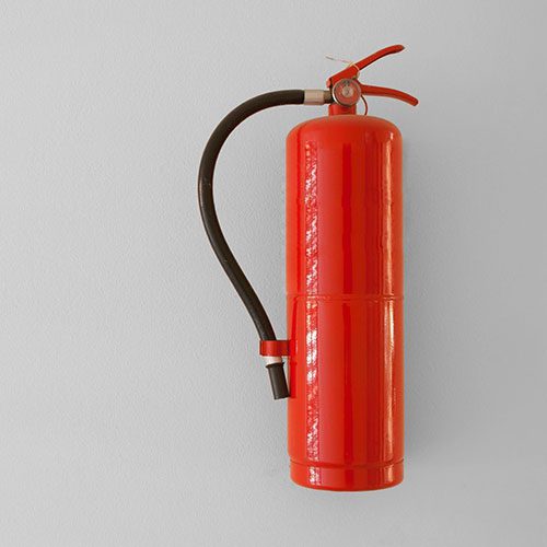 Red fire extinguisher on gray wall
