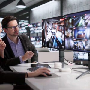Office workers analyzing multiple computer screens