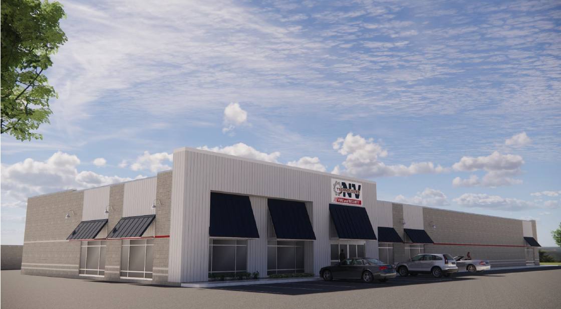 Commercial building with black awnings and trucks