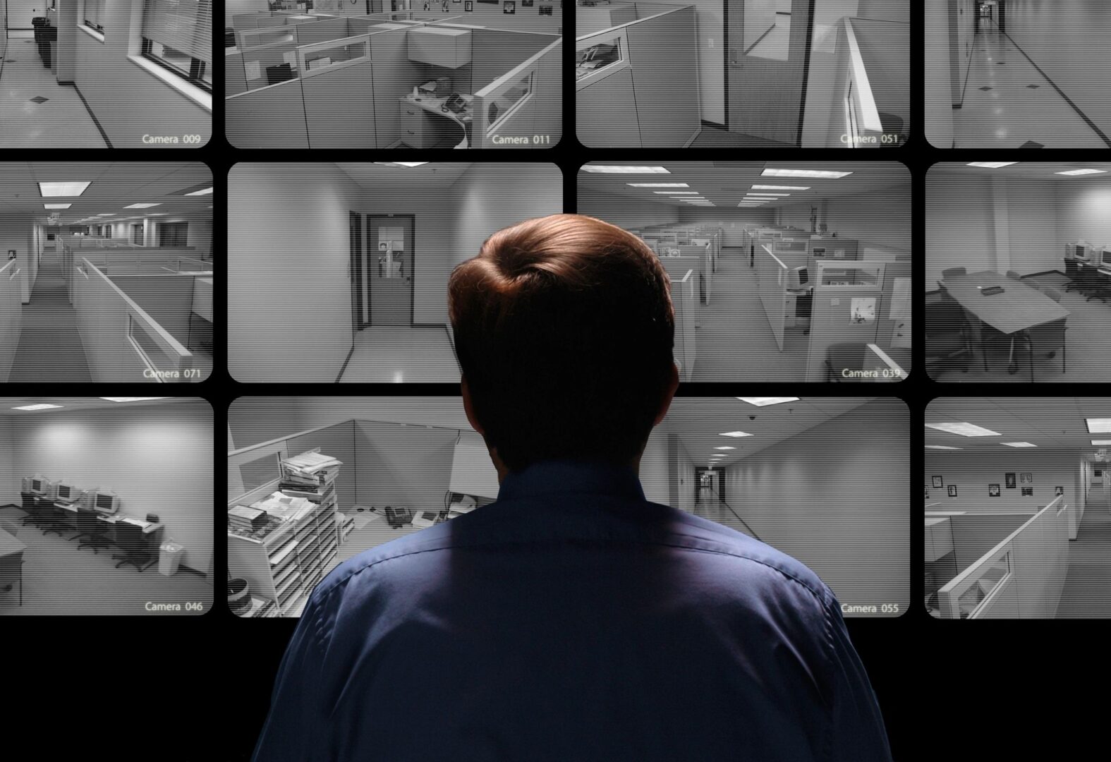 Person monitoring multiple office surveillance camera feeds